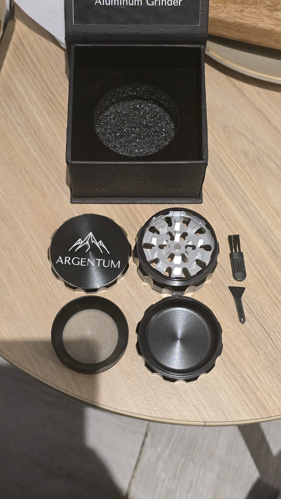 The complete ARGENTUM four-piece kit laid out with the cleaning brush and plastic scraper